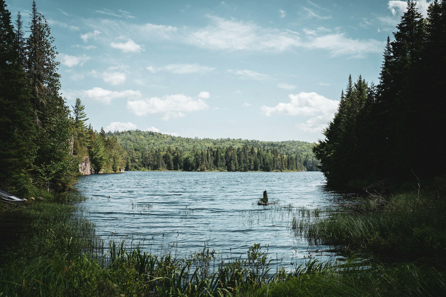 person sitting on rock in lake during daytime